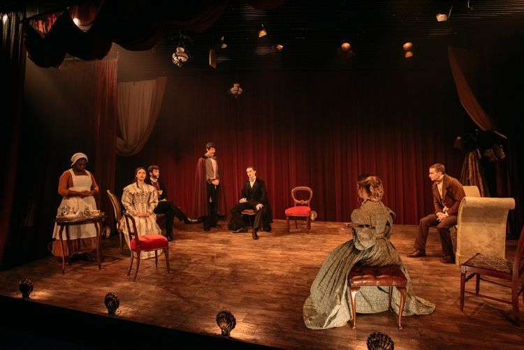 Group scene in Red Velvet with actors spaced around the set in period clothing
